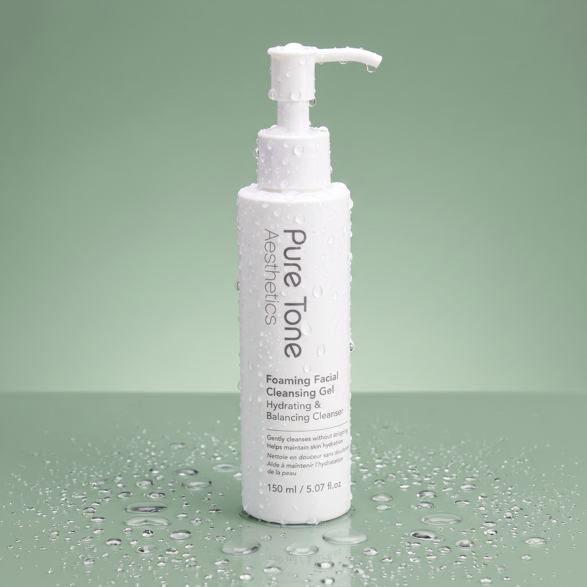 Pure Tone Aesthetics Foaming Facial Cleansing Gel standing on a reflective green surface with water droplets on the bottle and surrounding surface