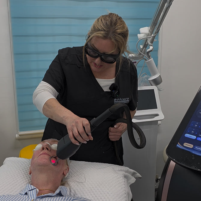 Woman administering a laser treatment to a patient in a clinical setting.