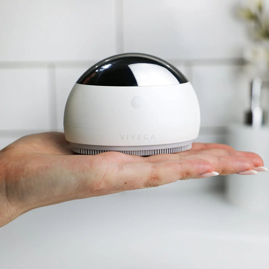 Pure Tone Viveca ultrasonic facial cleansing brush held in a hand