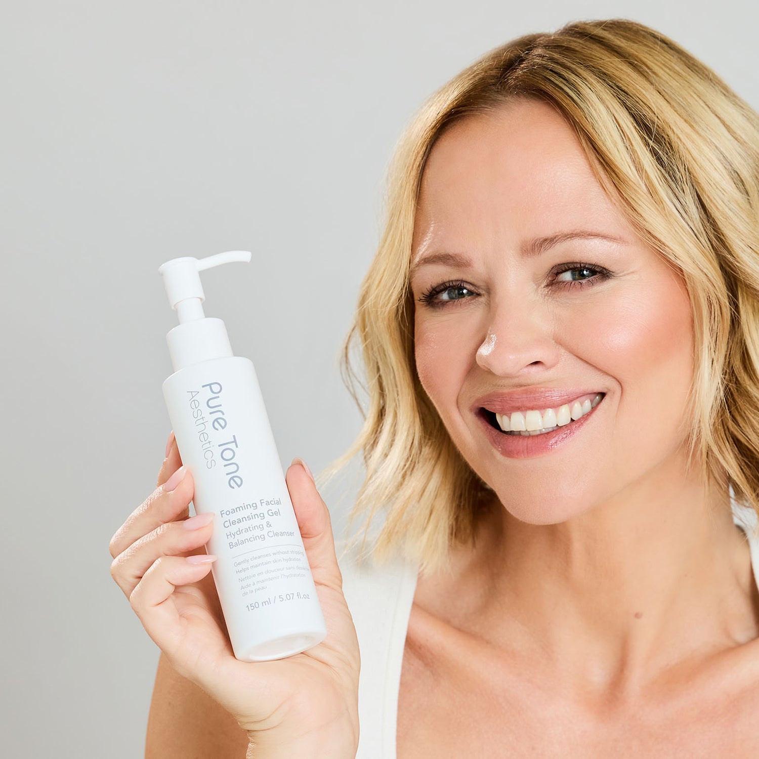 Close-up of Kimberley Walsh holding Pure Tone Aesthetics Foaming Facial Cleansing Gel