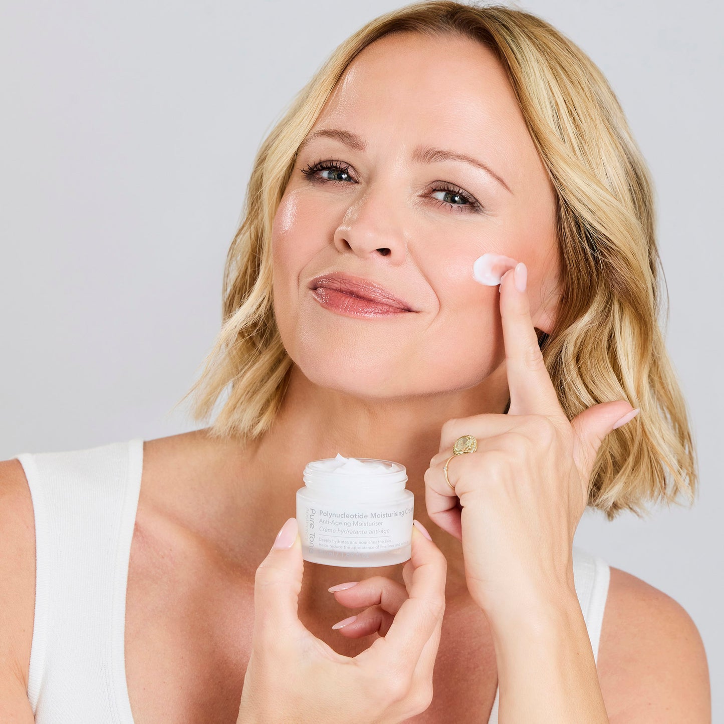 Kimberley Walsh applying Pure Tone Aesthetics Polynucleotide Moisturising Cream to her cheek