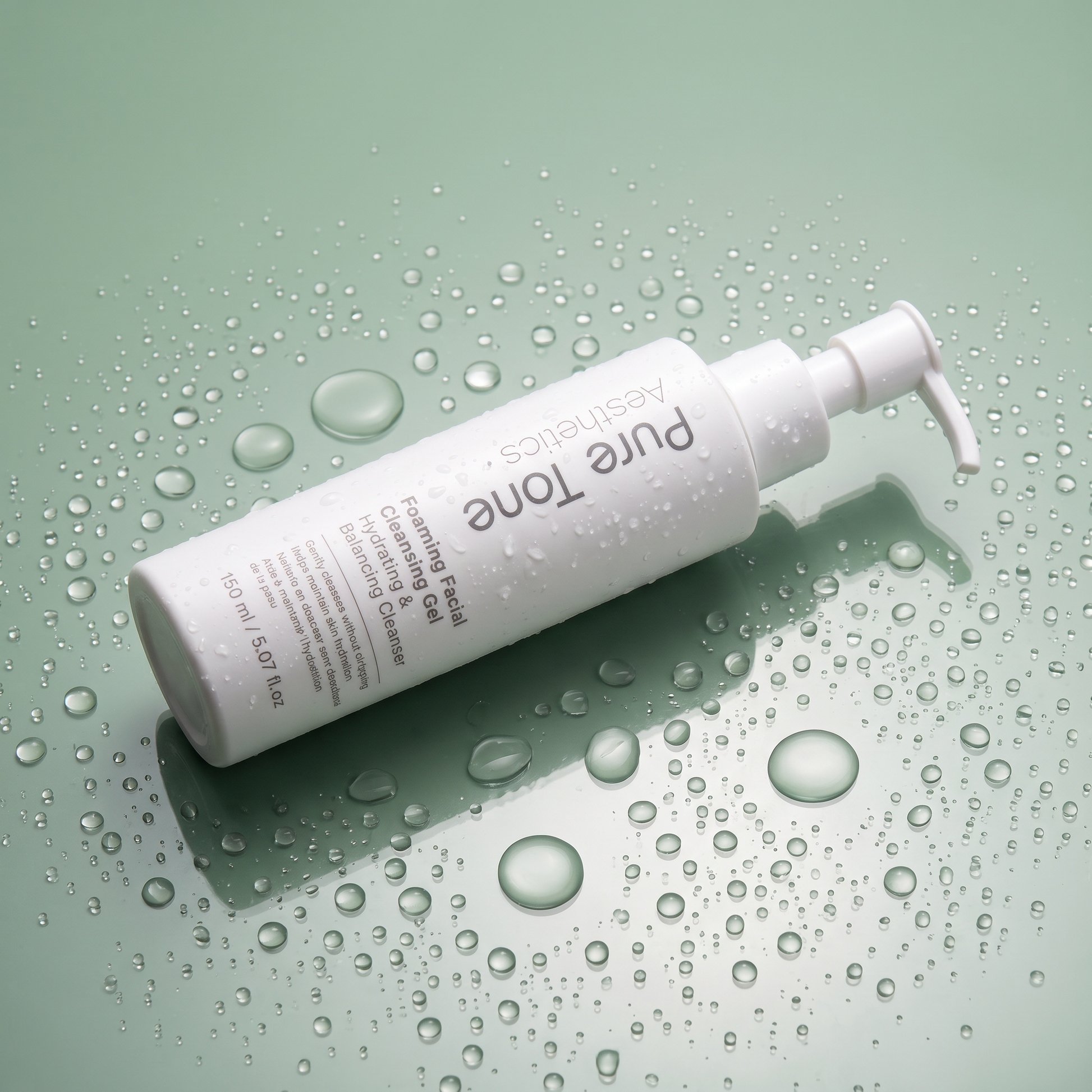 Pure Tone Aesthetics Foaming Facial Cleansing Gel bottle lying on a reflective green surface covered with water droplets
