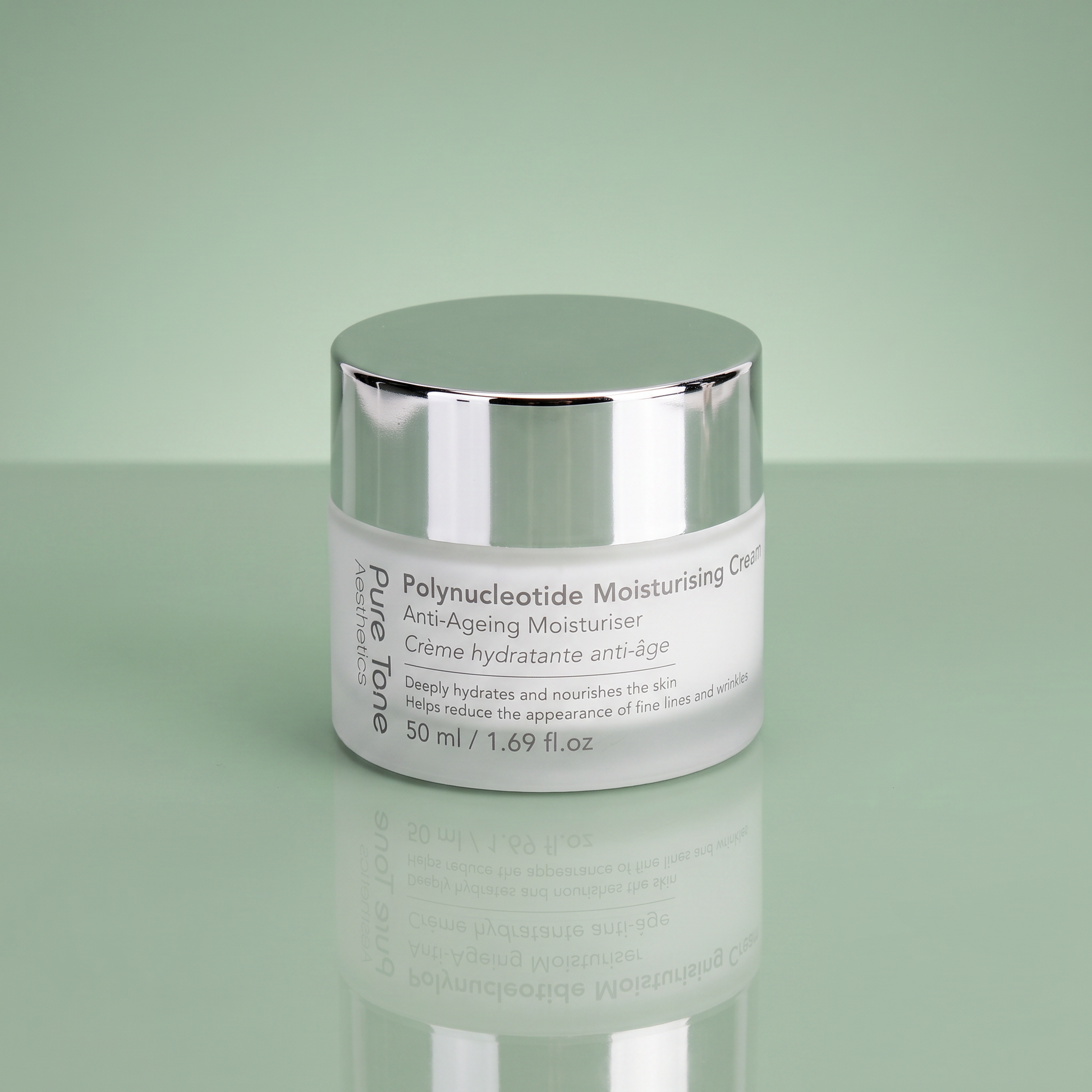 Pure Tone Aesthetics Polynucleotide Moisturising Cream jar with silver lid on a reflective soft green surface