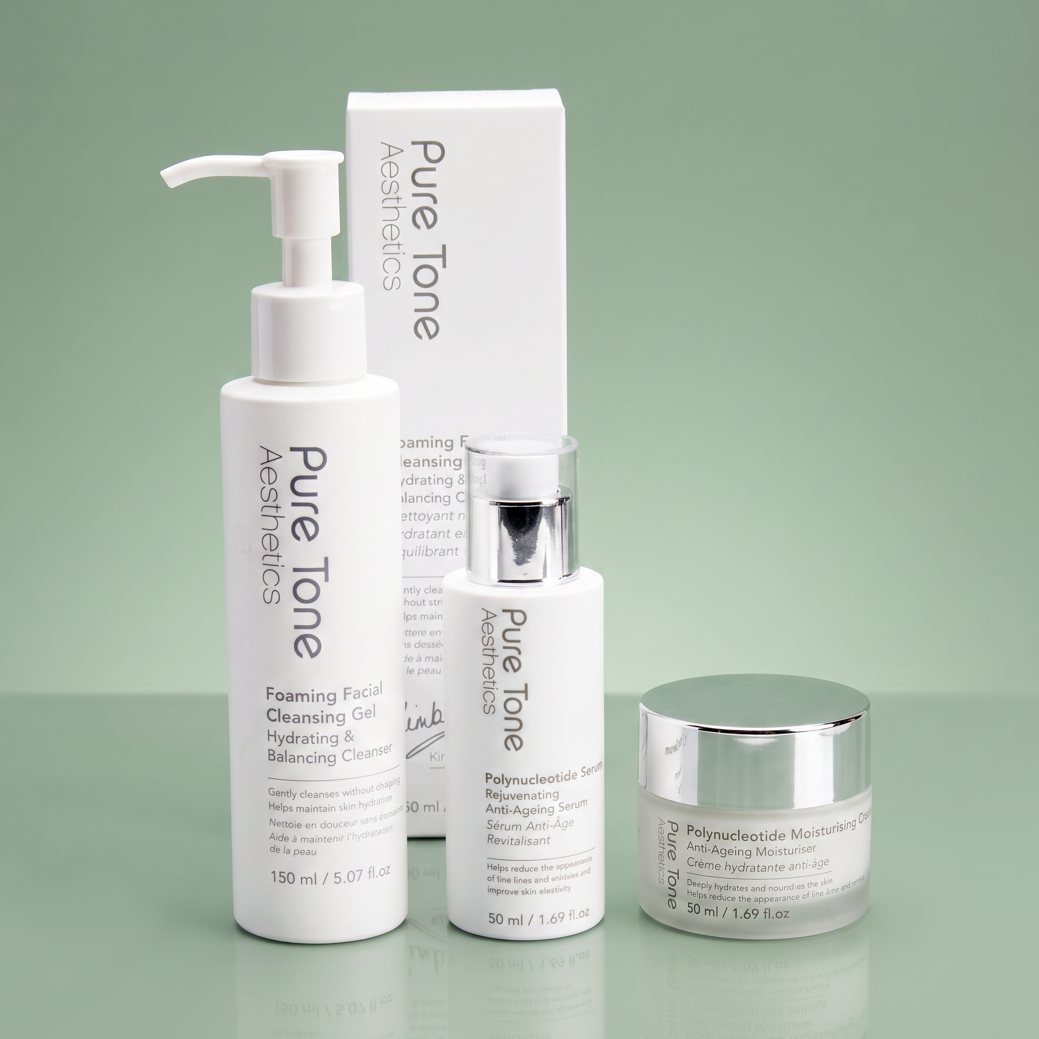 Pure Tone Aesthetics cleanser, polynucleotide serum and moisturising cream displayed with the Foaming Facial Cleansing Gel gift box on a reflective soft green surface